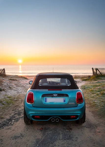 Rivedoux, Fransa, 01-08-2021 Ada 'da gün batımına bakan mavi araba.