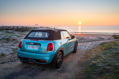 Rivedoux, Fransa, 01-08-2021 Ada 'da gün batımına bakan mavi araba.