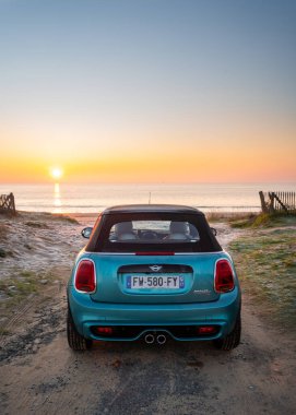 Rivedoux, Fransa, 01-08-2021 Ada 'da gün batımına bakan mavi araba.
