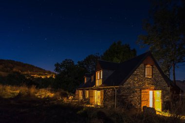 Authentic renovated Pyrenean barn in the Aure valley. exposed stone and wood construction. night shot