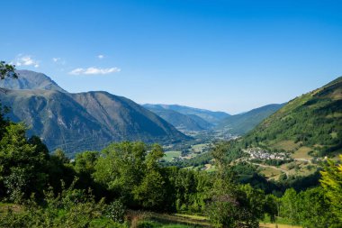 Bulutlu bir günde Fransız Pirenesi dağlarındaki vadi manzarası tipik bir Pyrenean köyü yüksekliğindedir.