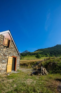 Aure Vadisi 'nde yenilenmiş otantik Pyrenean ahırı. Tahta çatı, açıkta taş ve ahşap yapı. Dağların muhteşem manzarası
