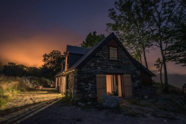 Authentic renovated Pyrenean barn in the Aure valley. exposed stone and wood construction. night shot
