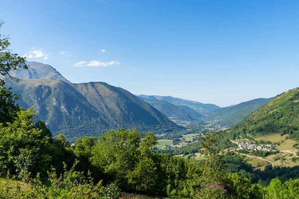 Bulutlu bir günde Fransız Pirenesi dağlarındaki vadi manzarası tipik bir Pyrenean köyü yüksekliğindedir.