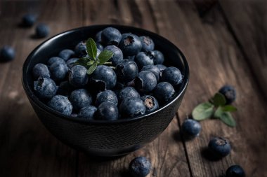Tahta bir masada siyah bir kasede taze yaban mersinlerinin yakın çekimi. yakın çekim görünümü
