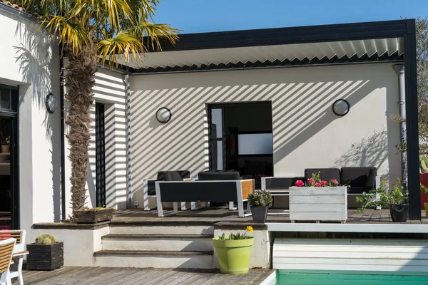 Açık hava pergola gölgelik yapısı, tente ve teras çatısı, bahçe salonu, sandalyeler, peyzaj ile çevrili metal ızgara.