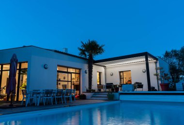 Modaya uygun teras pergola yapısı, tente ve teras çatısı, bahçe salonu, sandalyeler, peyzaj ile çevrili metal ızgara. İyi geceler.
