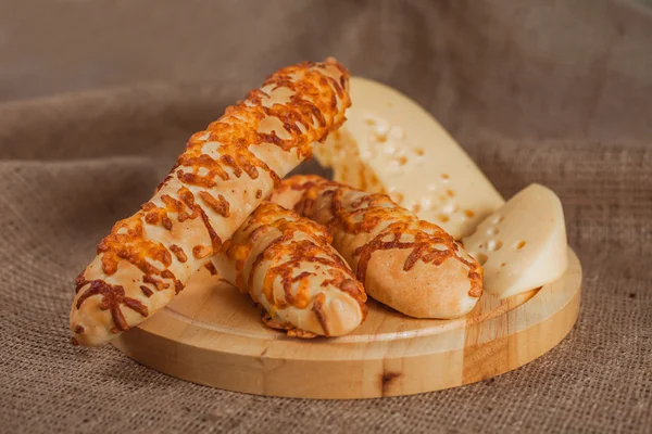 Baguettes with cheese on the wood tray. — Stock Photo, Image