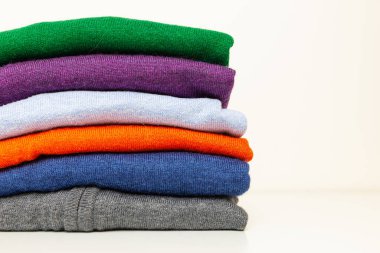 Farklı renkte sonbahar süveterleri üst üste dizilmiş. Kalın giysiler ve sonbaharın gelişi ve ilk soğuk algınlığı.. 