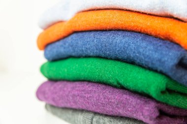 Farklı renkte sonbahar süveterleri üst üste dizilmiş. Kalın giysiler ve sonbaharın gelişi ve ilk soğuk algınlığı.. 