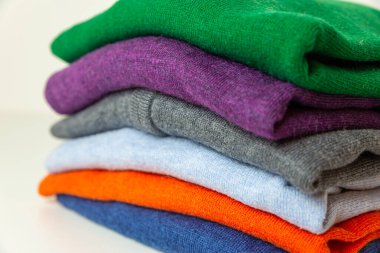 Farklı renkte sonbahar süveterleri üst üste dizilmiş. Kalın giysiler ve sonbaharın gelişi ve ilk soğuk algınlığı.. 