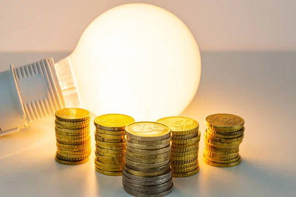小灯泡 旁边有硬币 提高能源关税 效率和节能 — 图库照片