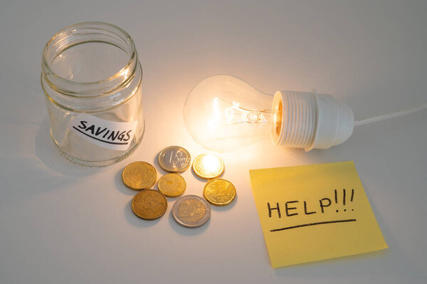 Light bulb on, with coins and empty piggy bank beside it, and a yellow note with the text "help". Increase in electricity bills.