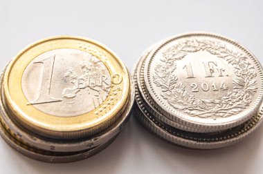 Beyaz yüzeyde Euro ve İsviçre Frangı paralar. İsviçre Frangı ve Euro ve döviz kuru trendlerinin değeri. İsviçre Frangı CHF 'ye karşı.
