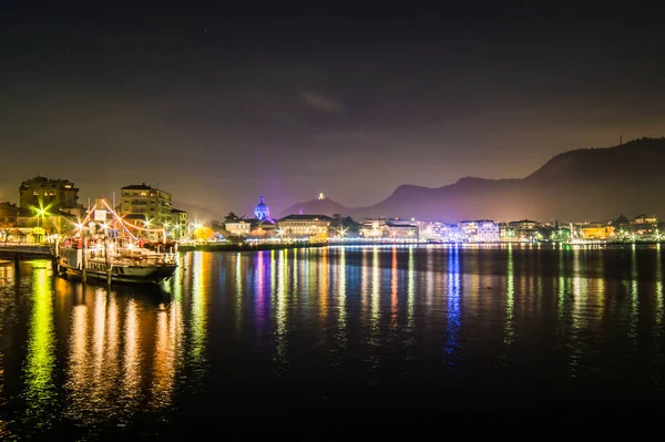 The city of Como, photographed in the evening, with the lakefront, the cathedral, and the surrounding mountains.