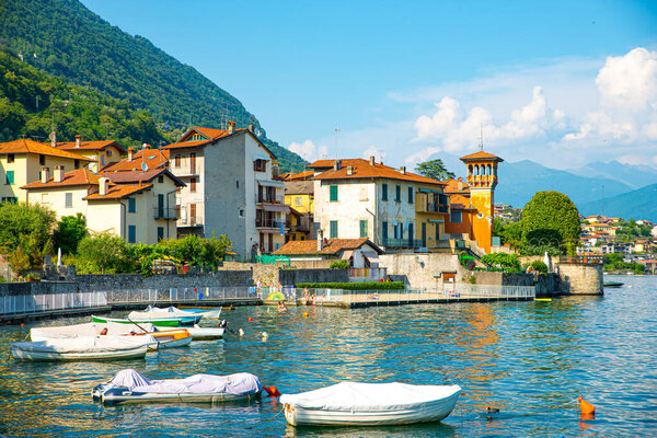 The town of Sala Comacina, with its boats, the marina and the lakefront, photographed in summer.