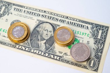 Euro, Dollar, Pound and Swiss Franc coins on white surface. Value of Swiss Franc, Dollar, Pound and Euro, exchange rate trend.