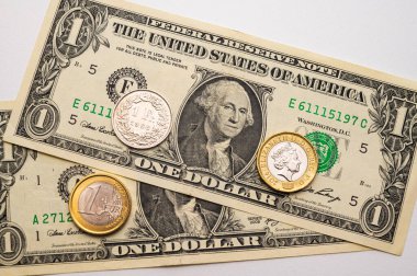 Euro, Dollar, Pound and Swiss Franc coins on white surface. Value of Swiss Franc, Dollar, Pound and Euro, exchange rate trend.