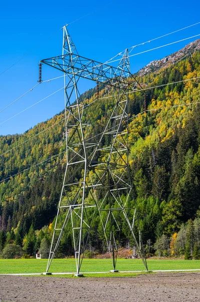 Electricity pylons, in a mountain place. Origin, transport and need for electricity. Environmental defacement. Eletricity grid.
