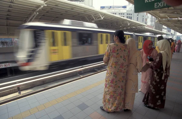 Malezya 'nın Kuala Lumpur kentindeki bir metro istasyonunda insanlar. Malezya, Kuala Lumpur, Ağustos 1997
