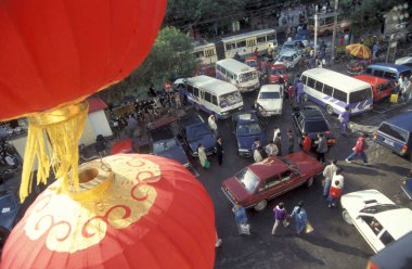 Çin 'deki Pekin' in merkezindeki bir alışveriş merkezinde insanlar ve trafikler. Çin, Pekin, Ekim 1997
