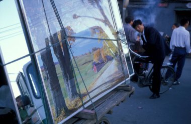 Çin 'in Pekin şehir merkezindeki ana yolda bisiklet trafiğinde bir sanat nakliyesi. Çin, Pekin, Ekim 1997