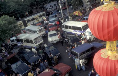 Çin 'deki Pekin' in merkezindeki bir alışveriş merkezinde insanlar ve trafikler. Çin, Pekin, Ekim 1997