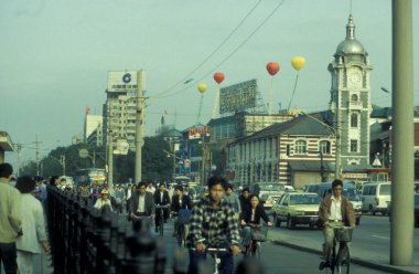 Çin 'in Pekin şehir merkezindeki bir kilisenin önündeki anayolda bisiklet trafiği. Çin, Pekin, Ekim 1997