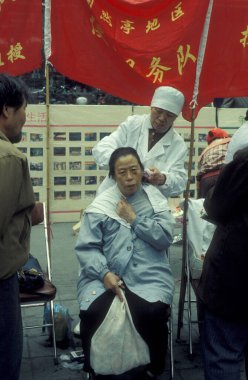 Çin 'in Pekin şehir merkezindeki sokakta devlet saç kesimi ya da kuaför hizmeti. Çin, Pekin, Ekim 1997