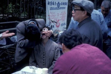 Çin 'in Pekin şehir merkezindeki caddede devlet sağlık diş hekimliği hizmeti. Çin, Pekin, Ekim 1997