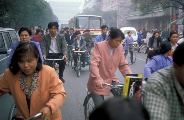 Çin 'in Pekin şehir merkezindeki ana yolda bisiklet trafiği var. Çin, Pekin, Ekim 1997