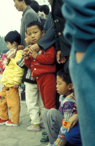 Bir çocuklu aile, Pekin 'deki Tiananmen Meydanı' ndaki Yasak Şehir ve İmparatorluk Sarayı 'nın önünde ve girişinde. Çin, Pekin, Ekim 1997
