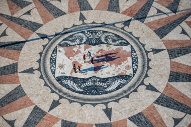 People walk on the giant world Map Mosaic or pavement at the Padrao dos Descobrimentos in Belem near the City of Lisbon in Portugal.  Portugal, Lisbon, October, 2021