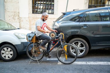 a knife grinder work on a Bicycle in Chiado in the City of Lisbon in Portugal. Portugal, Lisbon, October, 2021