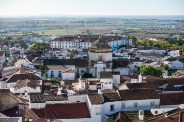 Komando da Instrucao e Doutrina ya da askeri üs, arkasında, ve Curch Igreja do Carmo, önde, Portekiz 'in Alentejo kentindeki Evora şehrinde. Portekiz, Evora, Ekim 2021