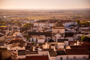 Komando da Instrucao e Doutrina ya da askeri üs, arkasında, ve Curch Igreja do Carmo, önde, Portekiz 'in Alentejo kentindeki Evora şehrinde. Portekiz, Evora, Ekim 2021