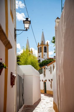 Portekiz 'in Alentejo şehrinde Nisa kasabasında Igreja de Nossa de Nossa da Graca da Matriz de Nisa ile küçük bir ara sokak. Portekiz, Nisa, Ekim 2021