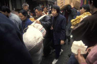 Pazarın yanındaki Marketstreet 'te ve Çin' in Hubei şehrindeki Wuhan şehrindeki otobüs terminalinde yük taşıyıcıları ile trafik sıkışıklığı. Çin, Wuhan, Kasım 1996