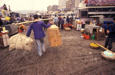 Çin 'in Hubei ilindeki Wuhan şehrindeki Otobüs Terminali' nde mal taşıyıcısı. Çin, Wuhan, Kasım 1996