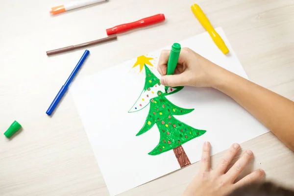 Çocuk noel ağacı çiziyor. Noel tatili. Çocuk Noel Baba 'ya bir mektup yaz.