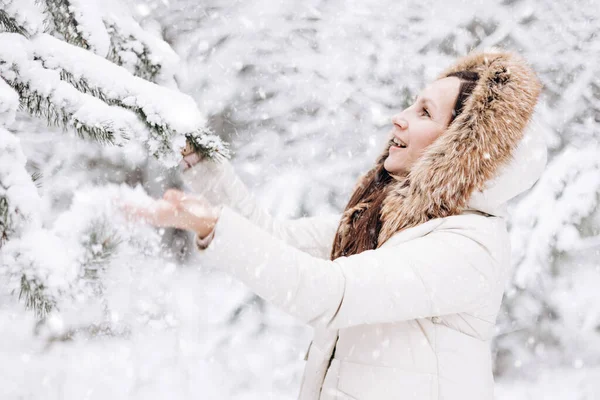 若い女性の冬の肖像画 幸せな女の子は冬の森の中を歩くと雪が降って探します クリスマスと新年の休日 スローライフ かわいいです女性で暖かい服で楽しいです自然屋外 — ストック写真