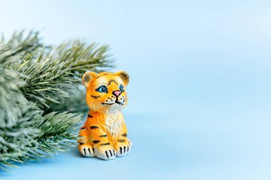 2022 Çin Yeni Yılı 'nın kaplan sembolü. Mavi pastel arka planda dalları olan bir kaplan heykeli. Boşluğu kopyala.