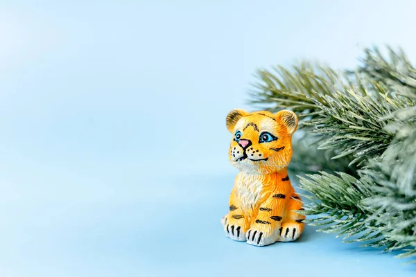 2022 Çin Yeni Yılı 'nın kaplan sembolü. Mavi pastel arka planda dalları olan bir kaplan heykeli. Boşluğu kopyala.