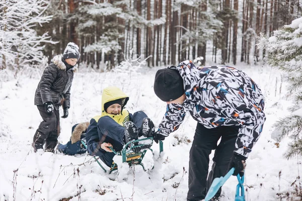 父と息子は一緒に冬の森をそり 楽しんでいます 雪の中で遊んでいる幸せな子供たちと若者 10代の男の子 かわいい幼児は霜の日に歩く 冬のアクティビティ — ストック写真