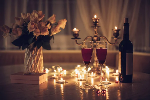 Mum ışığı randevusu. Şarap mumlu bardaklar gül buketi ve hediye kutusu. Romantik mum ışığında akşam yemeği.