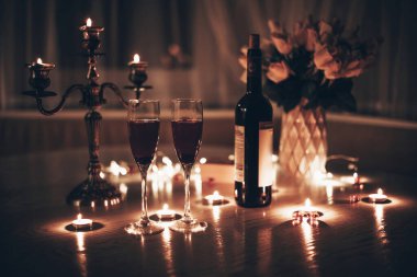 Mum ışığı randevusu. Şarap mumlu bardaklar gül buketi ve hediye kutusu. Romantik mum ışığında akşam yemeği.