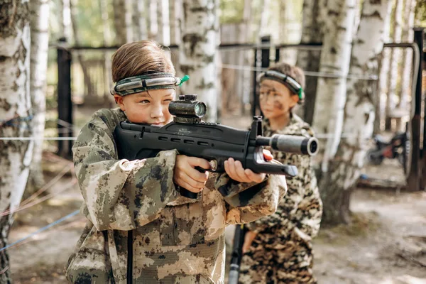 Çocuk optik görüşe bakıyor. Bir silah. Çocuklar dışarıda lazer savaşı oynuyorlar. Savaş simülasyon oyunu
