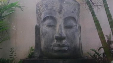 Asya ormanlarındaki büyük beton Buda heykelinin barışçıl yağmurlu manzarası, farkındalık meditasyonu, din ve tarihi dönüm noktası