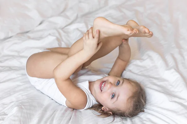 Criança Sorrindo Bebê Menina Bodysuit Branco Deitado Cama Casa Olhando — Fotografia de Stock