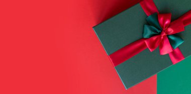 Yeşil ve kırmızı arka planda Noel tatili için hediye paketi. Yeni yıl hediyesi. Metin için boşluk kopyala, biçimlendir, pankart